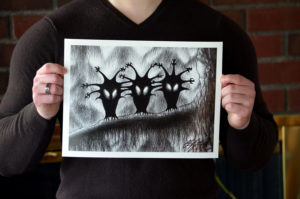 Detail of Christopher Paolini holding his print of the Shadow Birds.